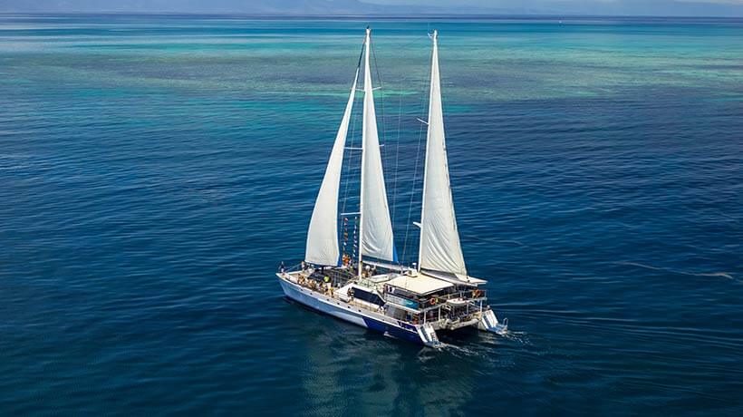 Sailing catamaran heading to the reef